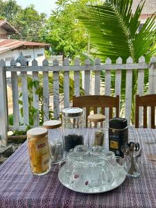 einen Tisch mit Gläsern und Gläsern auf einem lila Tischtuch in der Unterkunft Residence Boutique Hotel in Luang Prabang