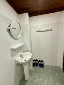 a white bathroom with a sink and a mirror at Residence Boutique Hotel in Luang Prabang