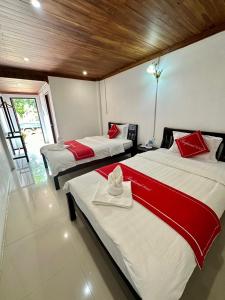 2 Betten mit roter und weißer Bettwäsche in einem Zimmer in der Unterkunft Residence Boutique Hotel in Luang Prabang