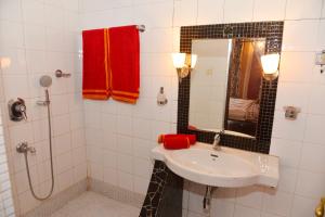 a white bathroom with a sink and a shower at Villa Fontainhas in Panaji