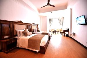 een slaapkamer met een groot bed en een eetkamer bij Araliya Red - Lean Luxury in Nuwara Eliya