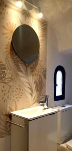 ein Bad mit einem Waschbecken und einem Wandspiegel in der Unterkunft Villa Crisantemos in Nerja