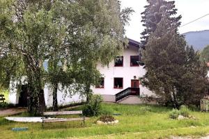 ein weißes Haus mit einem Baum davor in der Unterkunft CasaLucía - hometel in Puchberg am Schneeberg