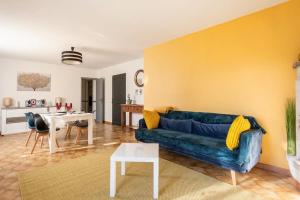 VILLA KAPETANAKIS في Redessan: غرفة معيشة مع أريكة زرقاء وطاولة