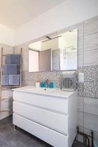 a white bathroom with a sink and a mirror at VILLA KAPETANAKIS in Redessan