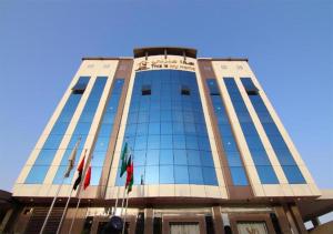a building with several flags in front of it at هذا منزلي الحمرا in Riyadh