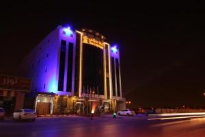 a building with purple lights on it at night at هذا منزلي الحمرا in Riyadh