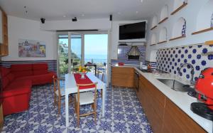 een keuken en een woonkamer met een rode bank bij Maison Lauren in Sorrento