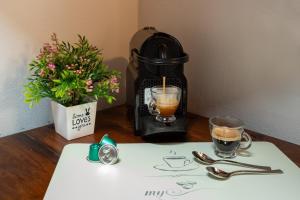 een koffiezetapparaat op een tafel met twee glazen bij Dante's Skyview - Appartamento mansarda Novara STAZIONE in Novara