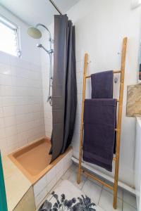La salle de bains est pourvue d'une douche avec rideau de douche. dans l'établissement Charmant T2 au cœur de Ducos, à Ducos