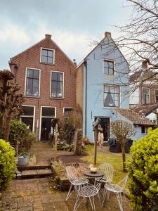 a patio with chairs and a table in front of a house at Caravan Stadstuin Goedereede let op de badkamer moet met andere gasten gedeeld worden in Goedereede +14 photos