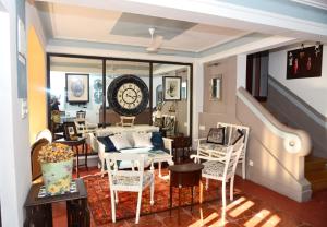 a living room with chairs and a clock on the wall at Casa Fontainhas in Panaji