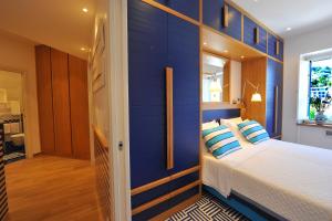 1 dormitorio con paredes azules y 1 cama con almohadas en Maison Lauren, en Sorrento