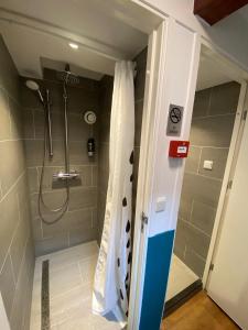 a bathroom with a shower with a shower curtain at Hotel Old Quarter in Amsterdam