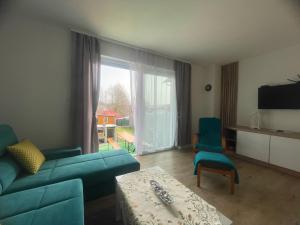 een woonkamer met een bank en stoelen en een groot raam bij Vila Mima in Nová Lesná