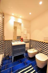 een badkamer met een wastafel, een toilet en een spiegel bij Maison Lauren in Sorrento