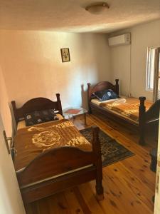 two beds in a room with wooden floors at Miky Apartments in Podgorica