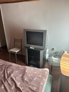 a living room with a television and a chair at Miky Apartments in Podgorica