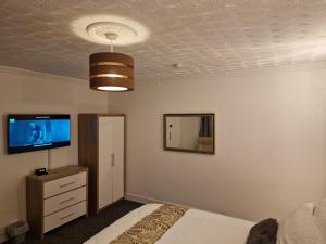 una camera con letto e TV sul soffitto di Steyn Guest Lodge a Buckinghamshire