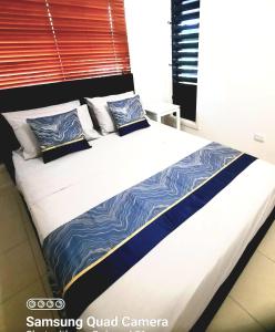un grande letto con lenzuola e cuscini blu e bianchi di ISLAND ROOM on Magnetic Island a Horseshoe Bay