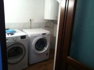 uma lavandaria com uma máquina de lavar roupa e uma máquina de lavar roupa em S'apposentu em Aritzo