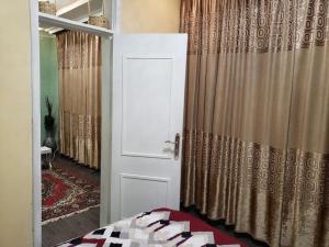sypialnia z białymi drzwiami i zasłoną w obiekcie Guest House at the center of Addis Ababa. w Addis Abebie