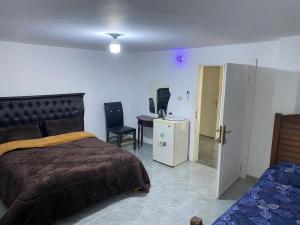 Dormitorio con cama, escritorio y TV en huseein rooms en Jarash