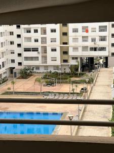 een balkon met uitzicht op een gebouw met een zwembad bij Luxury appart securise avec piscine in Agadir