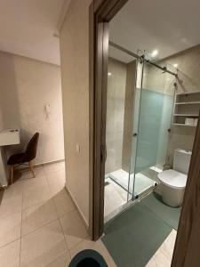 een badkamer met een glazen douche en een toilet bij Luxury appart securise avec piscine in Agadir