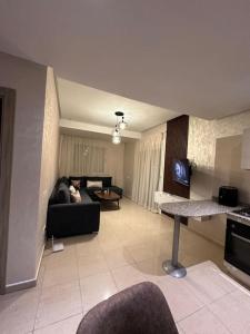 een woonkamer met een bank en een tafel bij Luxury appart securise avec piscine in Agadir