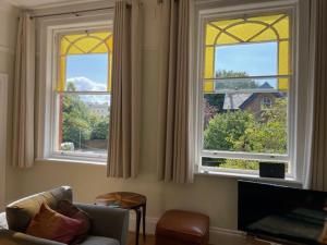 a living room with two windows and a couch at Beautifully Lit Airy 1-Bed Apartment in Liverpool in Liverpool