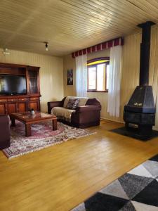 a living room with a couch and a wood stove at Pousada Água Santa in São Joaquim