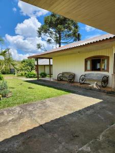 a dog sitting on a bench in front of a house at Pousada Água Santa in São Joaquim