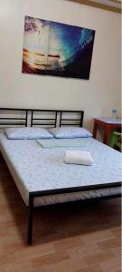 a bed in a room with a painting on the wall at Cody Homestay in Burgos