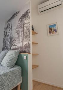 a bedroom with a picture of palm trees on the wall at Destination Grasse ! in Grasse