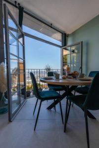 a dining room with a table and chairs and a balcony at Destination Grasse ! in Grasse