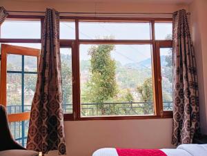 1 dormitorio con ventana y vistas en The White House - A Four Star Luxury Hotel en Shimla