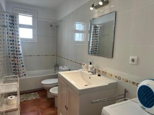 La salle de bains est pourvue d'un lavabo, de toilettes et d'un miroir. dans l'établissement Apartamento con jardín a 11 metros de la playa. B3., à Palamós