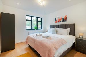 a bedroom with a large bed and a window at Cozy Two Bedrooms Flat in Coulsdon, CR5 in Coulsdon