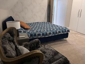 a bedroom with a bed and a chair next to a bed at Beautiful Penthouse By Seafront in Brighton & Hove