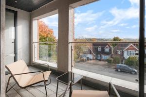 a balcony with chairs and a large window with a view at Cozy Two Bedrooms Flat in Coulsdon, CR5 in Coulsdon