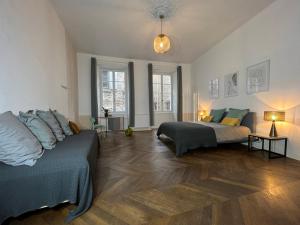 een woonkamer met 2 bedden en een bank bij Nature & Médiéval, gîte de charme 4 étoiles in Largentière
