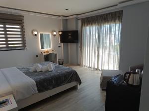 sypialnia z łóżkiem i dużym oknem w obiekcie Oikos 9 Rooms and Suites w mieście Nafpaktos