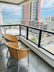 2 sillas sentadas en un balcón con vistas a la ciudad en Via Venetto Flat en Fortaleza