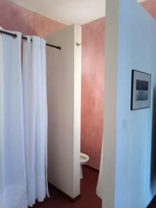 a bathroom with a white shower curtain and a toilet at Casa Azul in Mindelo