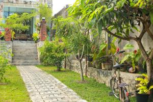 um jardim com um caminho de pedra e árvores e plantas em The Blue Haze Weligama em Weligama