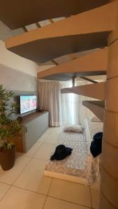 1 dormitorio con litera y TV en Laguna Beach Flat, en Porto de Galinhas