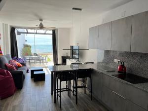 cocina y sala de estar con mesa y sillas en Newly Renovated 2 Bedroom Beachfront House en Sitio de Calahonda