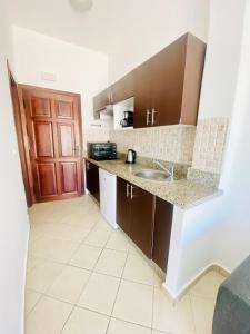 a kitchen with brown cabinets and a sink at Cabo Dream Apparthotel in Cabo Negro