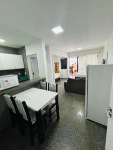 cocina con mesa blanca y nevera en Via Venetto Flat, en Fortaleza